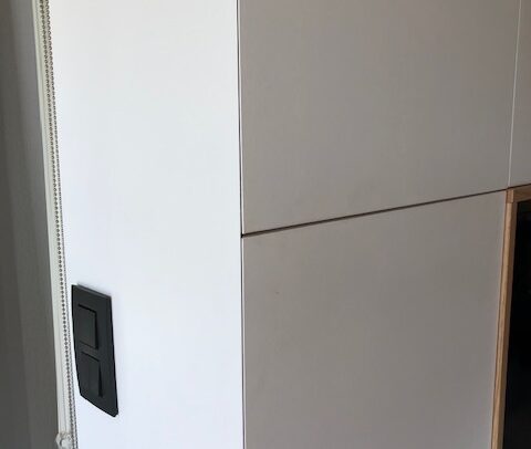Détail d'un meuble TV, portes à 45 °, charnières invisibles.